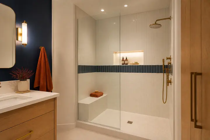 Design idea: a walk-in tiled shower with a bench and a band of navy tile